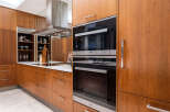 Experience modern luxury in this stunning kitchen, featuring sleek Miele appliances and rich wood cabinetry.