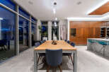 Experience modern luxury in this stunning dining area, featuring a sleek wooden dining table with comfortable upholstered chairs.
