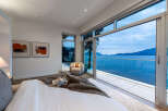 Experience breathtaking ocean views from this luxurious bedroom, featuring a spacious king-sized bed and a private balcony perfect for enjoying the serene coastal scenery.