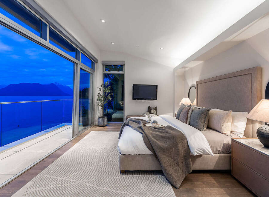 Experience unparalleled luxury in this master suite, featuring floor-to-ceiling windows that offer breathtaking ocean and mountain views.