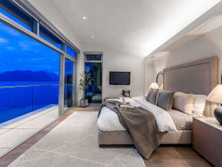 Experience unparalleled luxury in this master suite, featuring floor-to-ceiling windows that offer breathtaking ocean and mountain views.