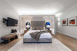 Experience ultimate comfort in this luxurious master bedroom, featuring a king-sized bed with a plush headboard and coordinated throw pillows.