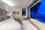 Experience breathtaking ocean views from this luxurious master bedroom, featuring a king-sized bed and direct access to a private balcony.