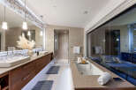 Experience luxury in this modern bathroom featuring dual vessel sinks atop a sleek, floating vanity with ample storage.