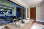 Experience luxury in this modern bathroom featuring a deep soaking tub with a sleek chrome faucet and a convenient bath tray.