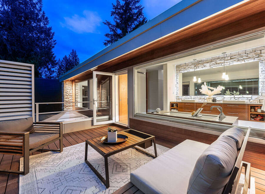 Experience modern luxury with this stunning outdoor living space, featuring a sleek deck and comfortable seating perfect for relaxation.