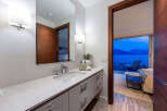 Experience luxury living with this stunning bathroom featuring a sleek vanity, modern fixtures, and a large mirror.