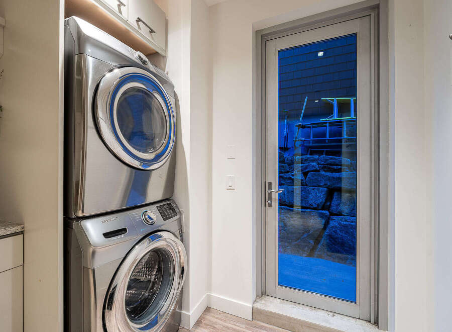Discover a functional laundry space featuring a sleek, stacked Samsung washer and dryer set.