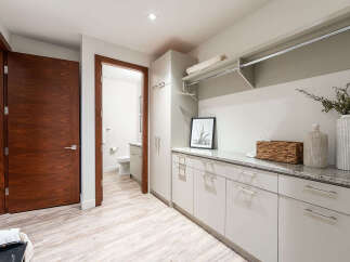 Discover this spacious laundry room featuring sleek, modern cabinetry and a durable granite countertop, perfect for folding and organizing.
