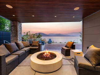 Experience breathtaking sunset views from this luxurious outdoor living space, complete with a modern fire pit and comfortable seating.