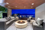 Experience luxurious outdoor living with this stunning patio featuring a modern sectional sofa and a captivating fire pit.