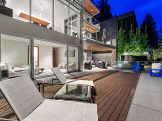 Experience modern luxury in this stunning multi-level home, featuring expansive glass walls that seamlessly blend indoor and outdoor living.
