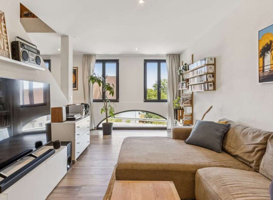 Experience modern living in this stylish apartment featuring a spacious open-plan living area with a large sectional sofa and entertainment center.