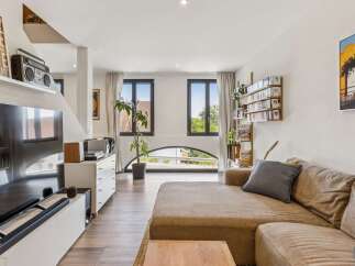 Experience modern living in this stylish apartment featuring a spacious open-plan living area with a large sectional sofa and entertainment center.