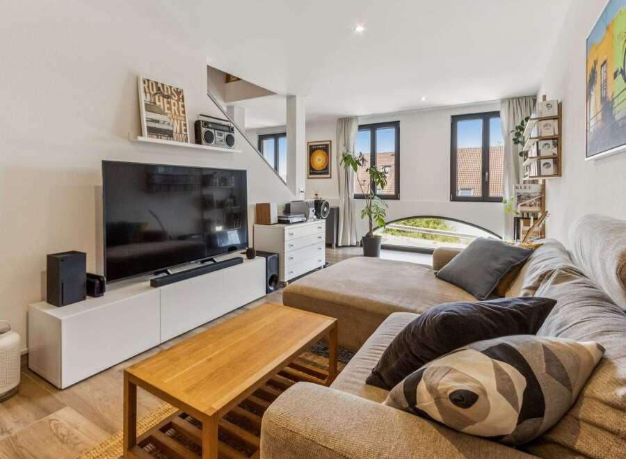 Experience modern living in this stylish living room, featuring a large sectional sofa perfect for relaxation and entertainment.