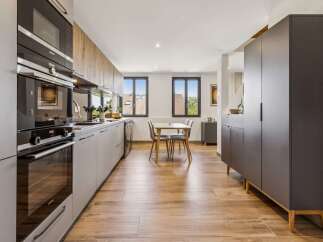 Discover this modern kitchen featuring sleek grey cabinetry and integrated Siemens appliances, including a microwave and oven.