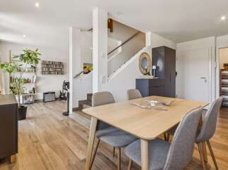 Discover this inviting dining area featuring a light wood table with comfortable upholstered chairs, perfect for family meals.