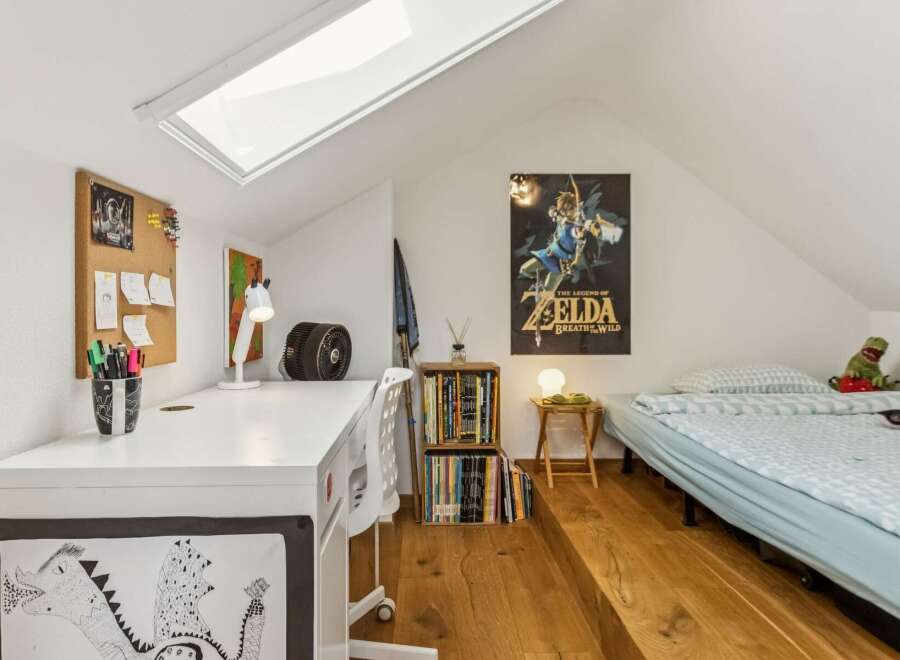This attic bedroom offers a unique and functional living space, perfect for a child or young adult.