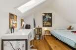 This attic bedroom offers a unique and functional living space, perfect for a child or young adult.