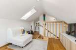 Discover this charming loft space featuring a comfortable white sofa, perfect for relaxing after a long day.
