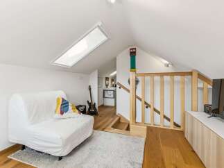 Discover this charming loft space featuring a comfortable white sofa, perfect for relaxing after a long day.