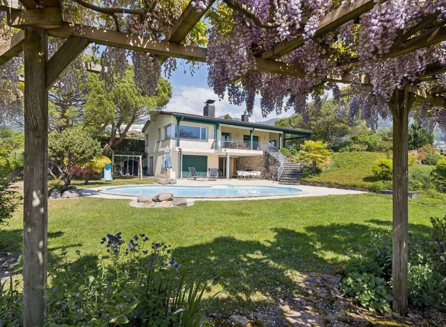 Experience luxurious outdoor living with this stunning property featuring a sparkling swimming pool and a charming wisteria-covered pergola.