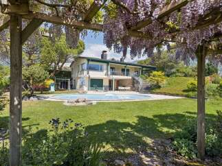Experience luxurious outdoor living with this stunning property featuring a sparkling swimming pool and a charming wisteria-covered pergola.