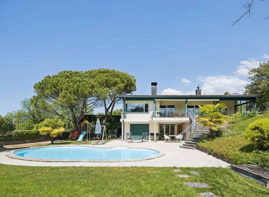 Experience luxurious outdoor living with this stunning property featuring a sparkling swimming pool and a dedicated children's play area.