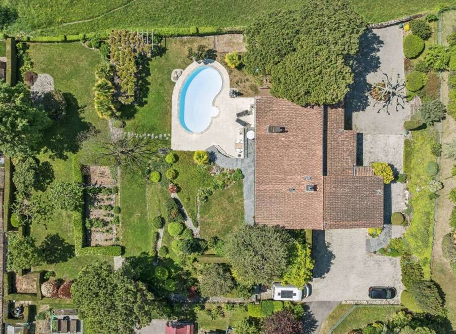 Discover this stunning property featuring a kidney-shaped swimming pool surrounded by a paved patio, perfect for relaxation and entertaining.