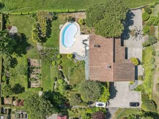 Discover this stunning property featuring a kidney-shaped swimming pool surrounded by a paved patio, perfect for relaxation and entertaining.