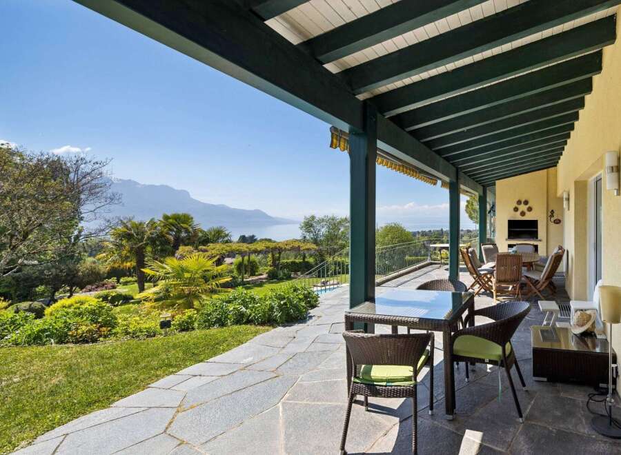 Enjoy breathtaking lake and mountain views from this stunning covered patio, perfect for al fresco dining or relaxing with a view.