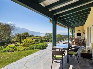 Enjoy breathtaking lake and mountain views from this stunning covered patio, perfect for al fresco dining or relaxing with a view.