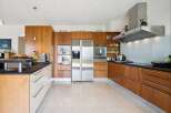 This modern kitchen boasts sleek, custom wood cabinetry and a spacious stainless steel refrigerator.
