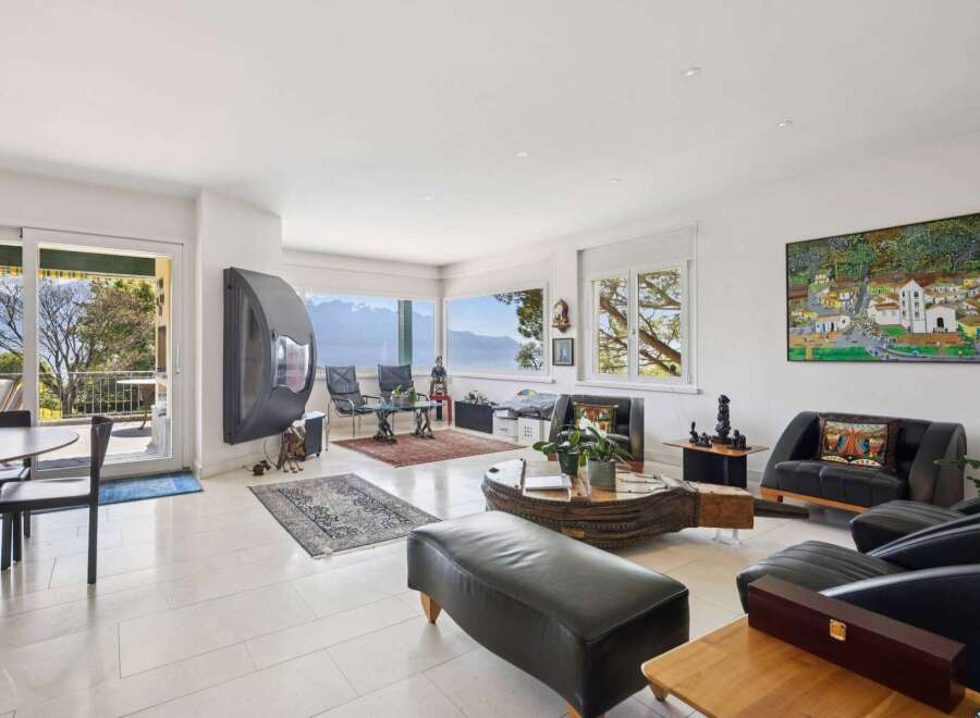 Experience breathtaking panoramic views from this stunning living room, featuring a modern fireplace and expansive windows that capture the natural beauty outside.