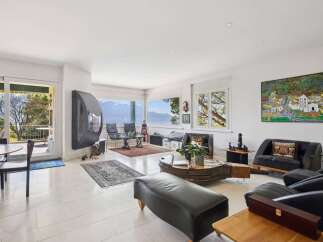 Experience breathtaking panoramic views from this stunning living room, featuring a modern fireplace and expansive windows that capture the natural beauty outside.