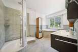 Experience luxury and relaxation in this stunning bathroom featuring a spacious walk-in shower with elegant tilework and a deep soaking tub perfect for unwinding.