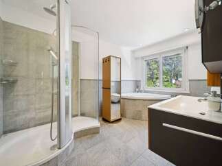 Experience luxury and relaxation in this stunning bathroom featuring a spacious walk-in shower with elegant tilework and a deep soaking tub perfect for unwinding.