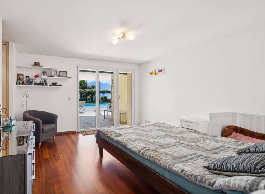 Experience luxurious living with this stunning bedroom featuring a spacious bed and direct access to a beautiful outdoor pool and garden area.