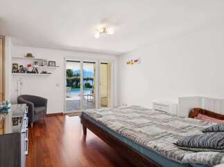 Experience luxurious living with this stunning bedroom featuring a spacious bed and direct access to a beautiful outdoor pool and garden area.