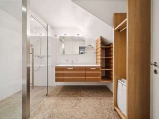 This modern bathroom features a spacious walk-in shower with sleek glass doors and a rainfall showerhead.