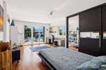 This spacious bedroom offers a serene retreat with stunning views of a private pool and a picturesque lake.