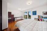 This modern bedroom offers a serene retreat with its spacious layout and abundant natural light.