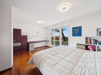 This modern bedroom offers a serene retreat with its spacious layout and abundant natural light.