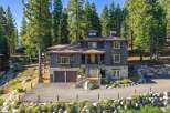 Nestled amidst towering pine trees, this stunning mountain home offers a serene retreat with its natural stone accents and dark wood siding.