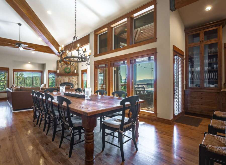 Experience luxurious mountain living in this stunning dining room, featuring a grand wooden table perfect for hosting.