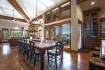 Experience luxurious mountain living in this stunning dining room, featuring a grand wooden table perfect for hosting.