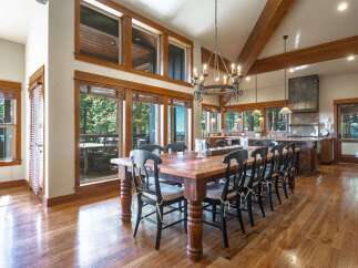 Experience luxurious mountain living in this stunning dining room, featuring a grand wooden table with seating for ten, perfect for hosting memorable gatherings.