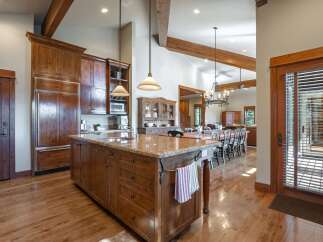 Experience rustic elegance in this spacious kitchen featuring custom wood cabinetry and a large granite island perfect for entertaining.