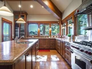 Experience rustic elegance in this spacious kitchen, featuring warm wooden cabinetry and granite countertops.
