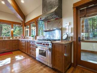 Experience rustic elegance in this stunning kitchen, featuring rich wood cabinetry and a professional-grade Wolf range.